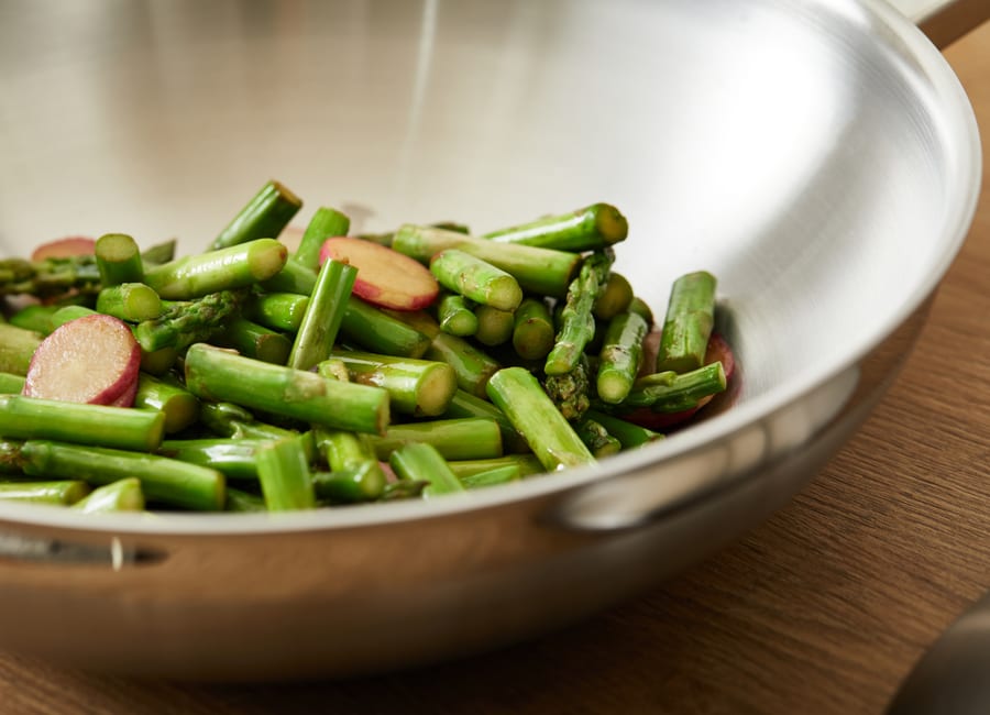 Stainless steel wok with cooked vegetables
